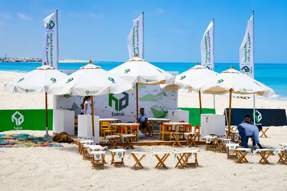 HDB branded beach lounge with white umbrellas and flags